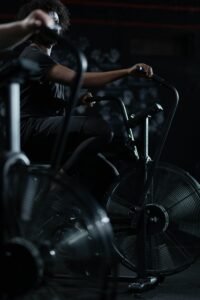Adult exercising in a gym on a stationary bike, embracing a healthy lifestyle.